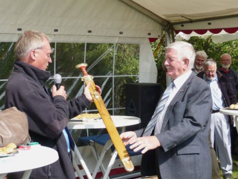Formanden for Nydamselskabet overrækker A.P.Hansen sin gave, et sværd, kopi at et fra Nydam Mose.